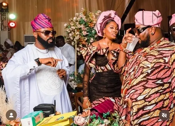 Guests in matching pink gele and prints celebrating at a birthday party