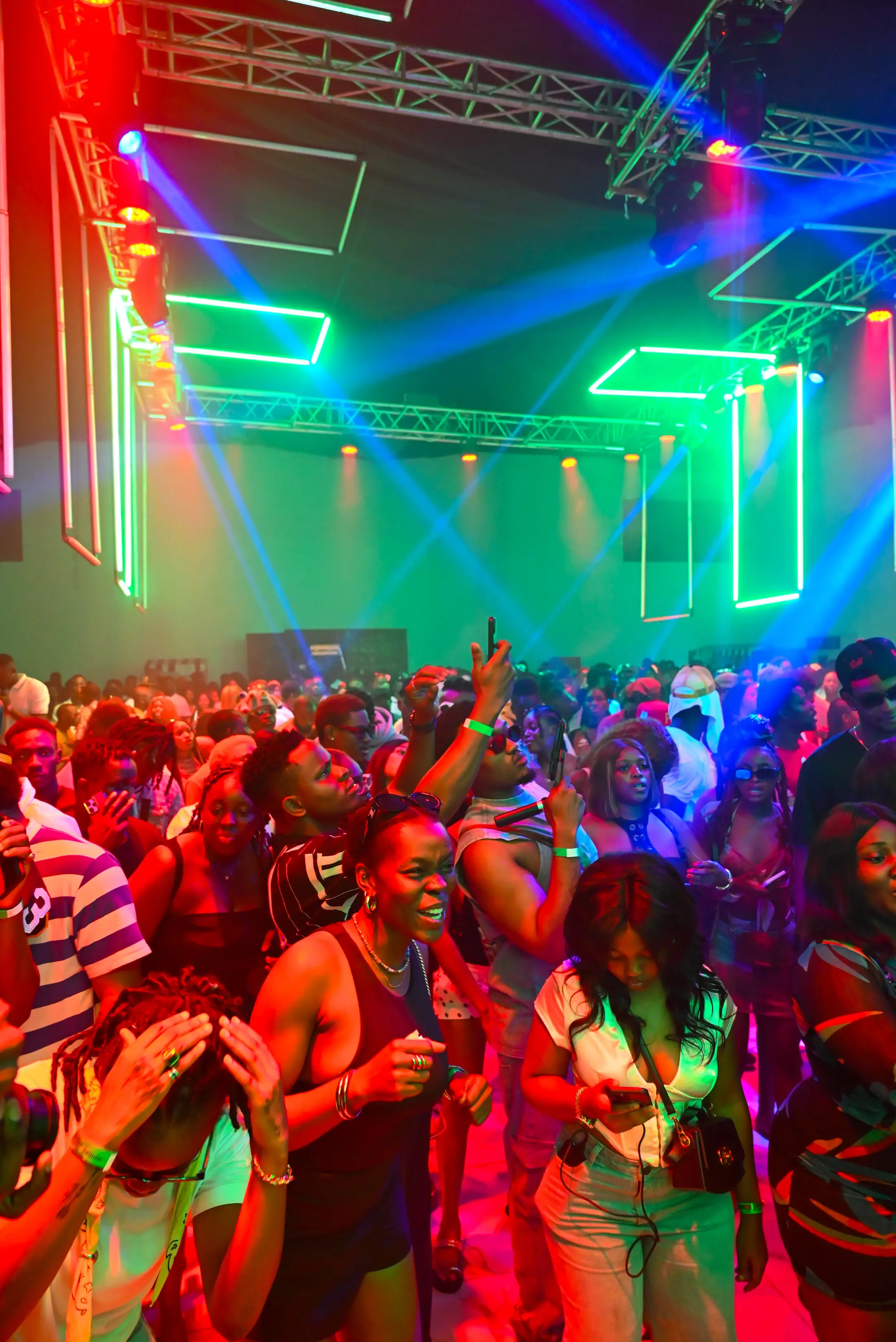 A packed dance floor under coloured stage lights