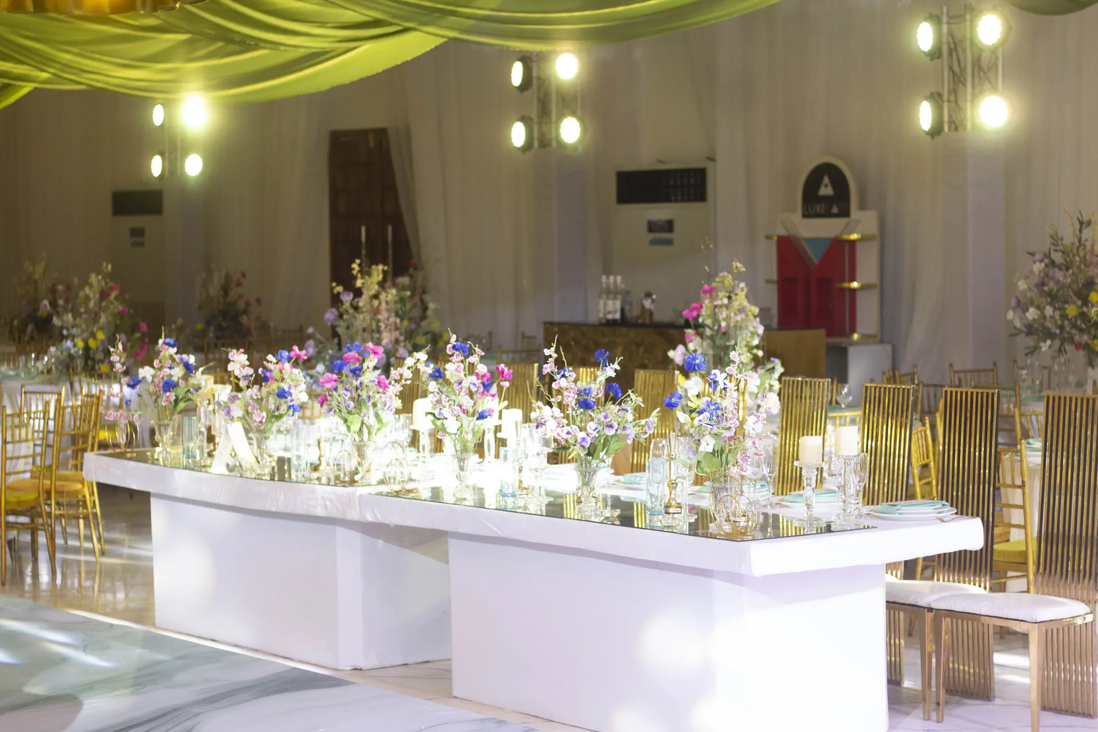 A long white banquet table dressed with flowers and candles in the hall