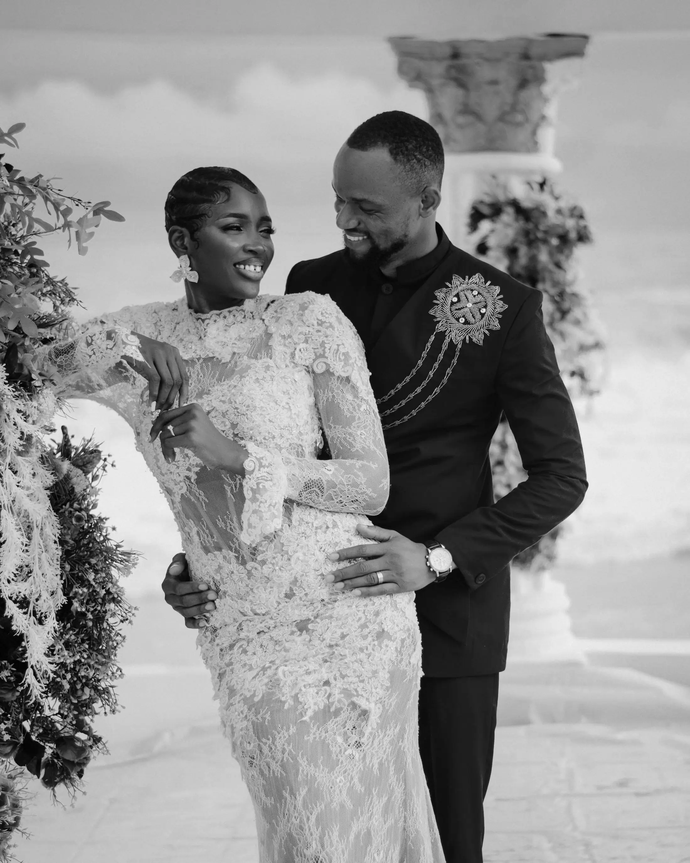 Black and white portrait of a bride and groom between the columns