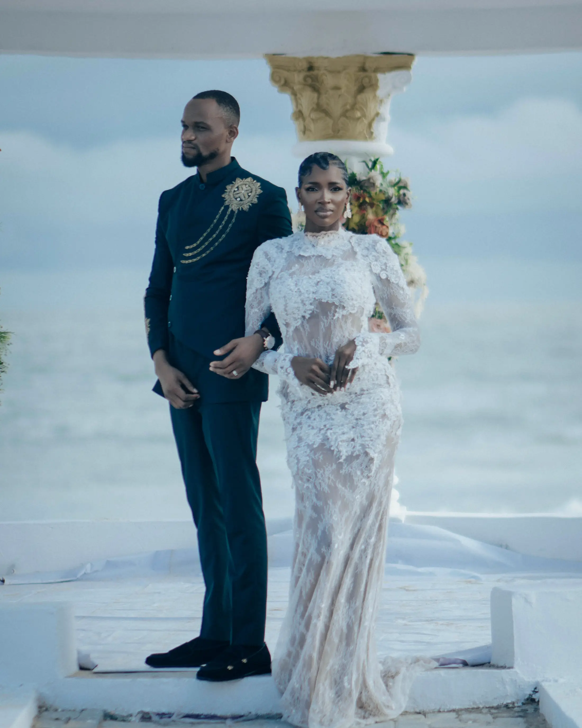 A couple standing at the gazebo, the sea behind