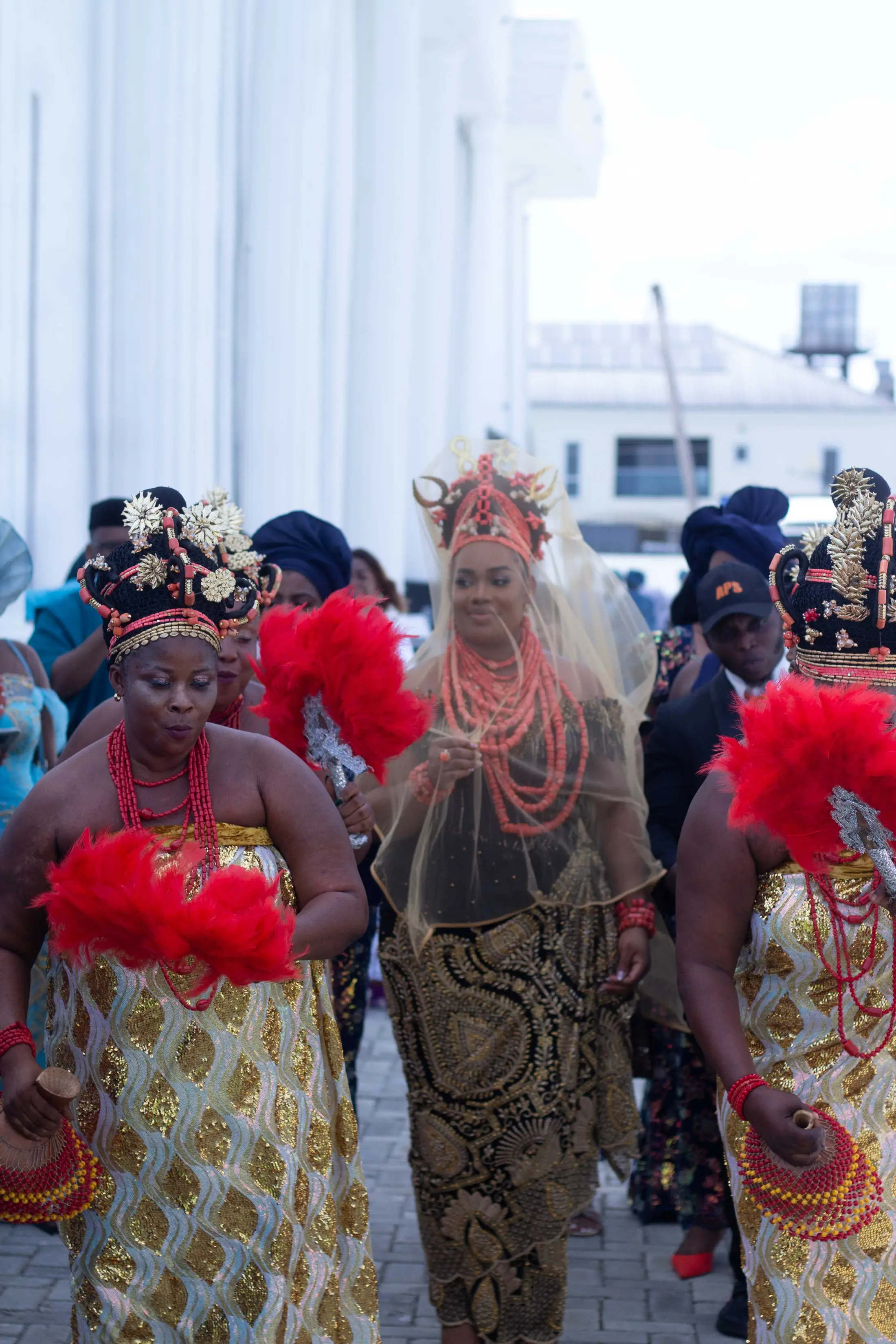 The bride's party arriving with red fans and coral beads