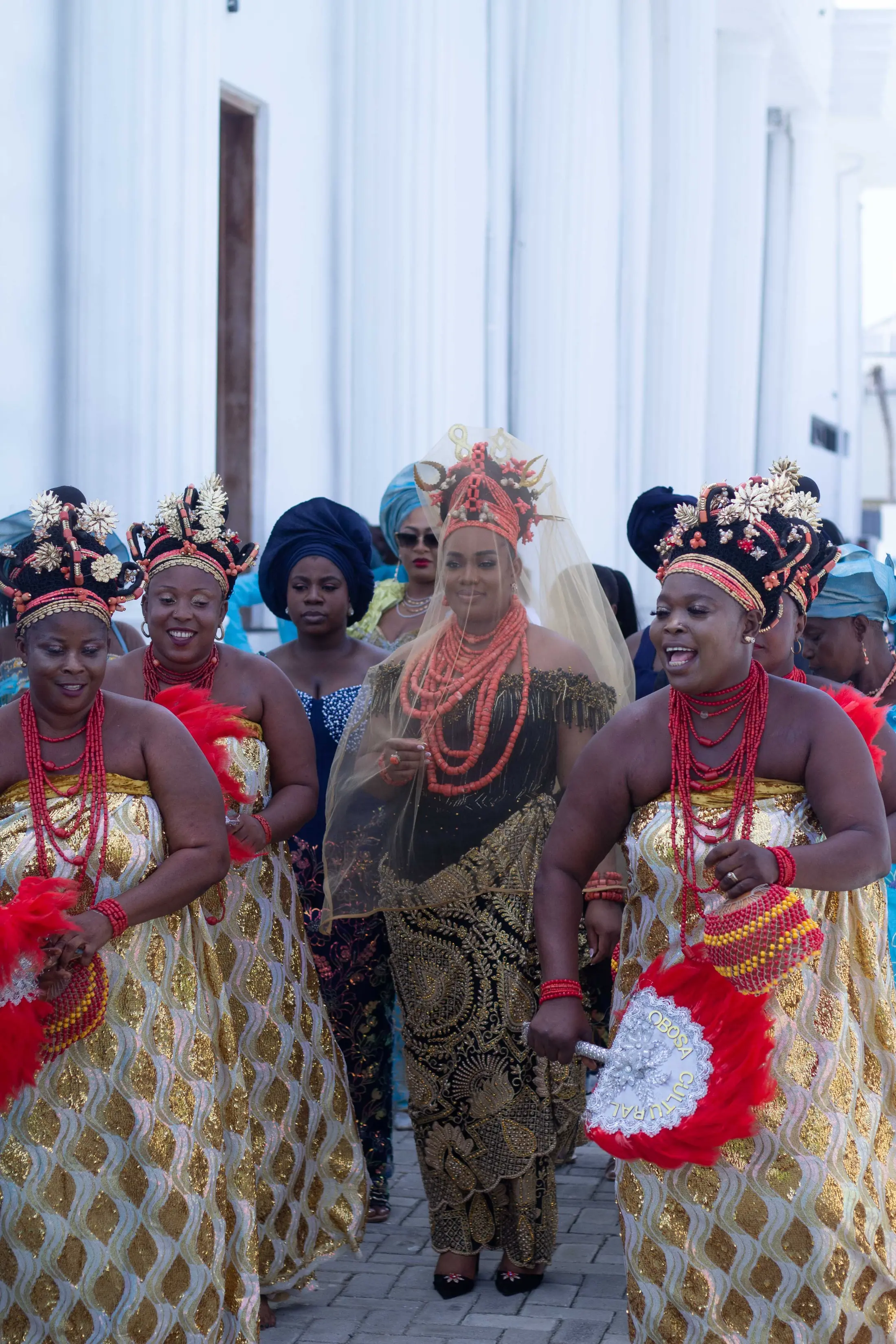 Coral beads and gold wrappers as the procession arrives