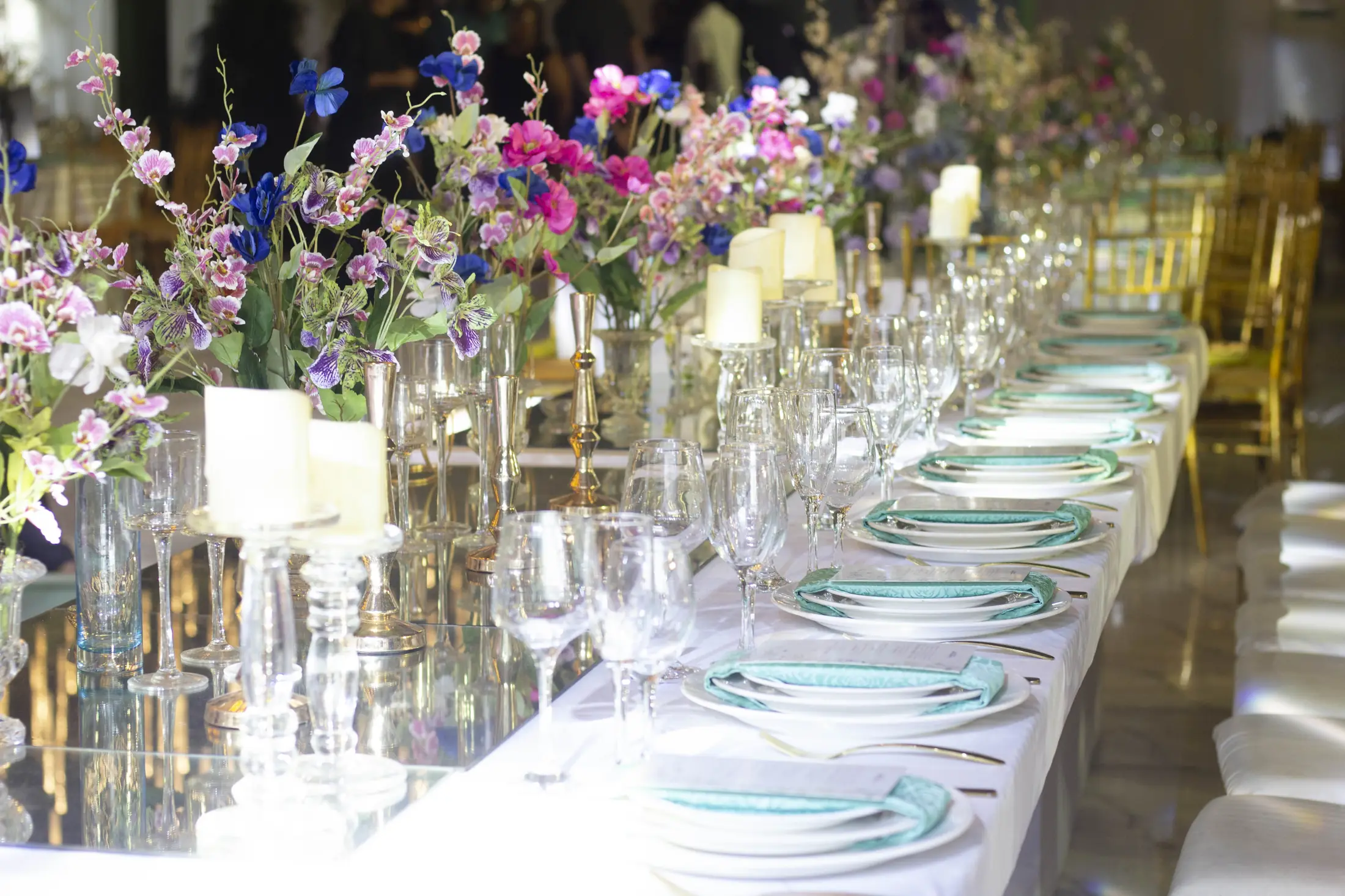 Flowers massed along a white reception table