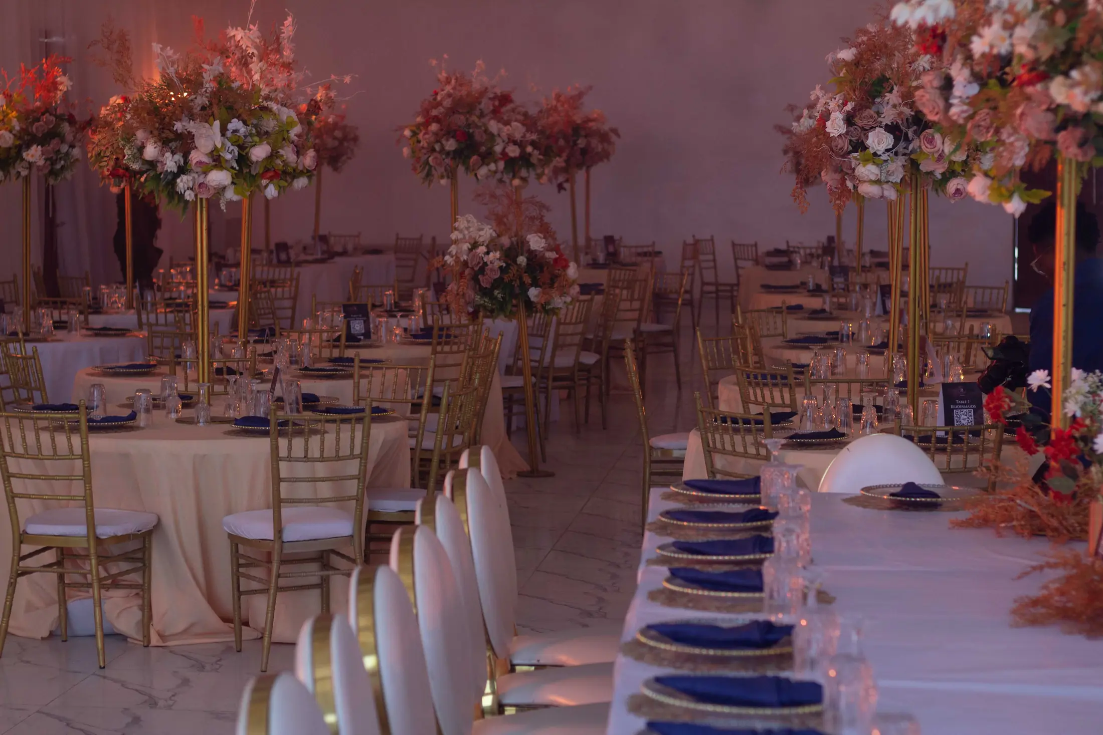 Blush flowers and candles along a dressed reception table